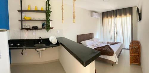 een kleine keuken met een wastafel en een bed in een kamer bij Bella vista Itacimirim in Camassari