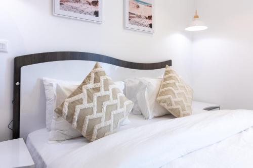 a bedroom with a white bed with white pillows at Modern Studio Apartment, Lennox in Accra