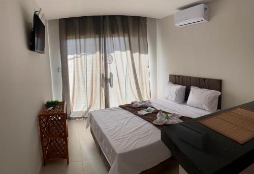 a bedroom with a large bed and a window at Bella vista Itacimirim in Camacari