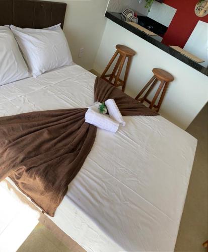 a bed with two towels on it with two chairs at Bella vista Itacimirim in Camacari