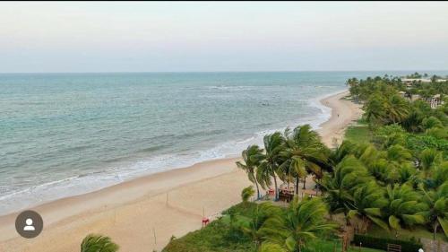 an aerial view of a beach with palm trees and the ocean at Bella vista Itacimirim in Camacari