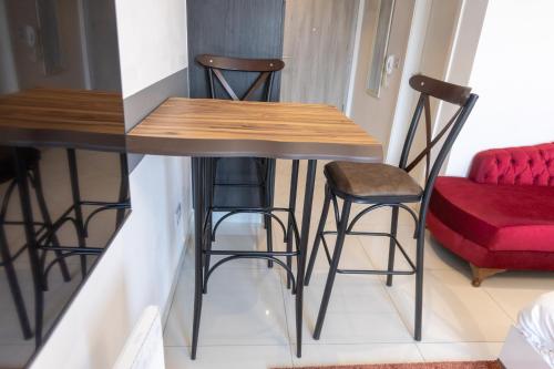 a table and stools in a room with a red couch at Modern Studio Apartment, Lennox in Accra