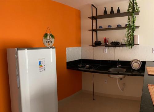a kitchen with a white refrigerator and a sink at Bella vista Itacimirim in Camacari
