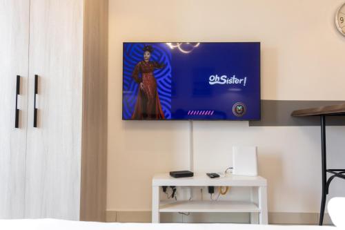 a tv hanging on a wall in a living room at Modern Studio Apartment, Lennox in Accra