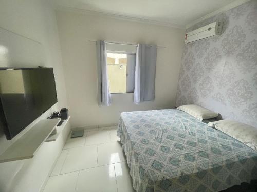 Apto próximo do Centro de Porto في بورتو سيغورو: غرفة نوم صغيرة بها سرير وتلفزيون