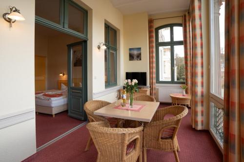 Zimmer mit einem Tisch und Stühlen sowie einem Schlafzimmer in der Unterkunft Villa Stock Appartement mit großer Veranda in Heringsdorf