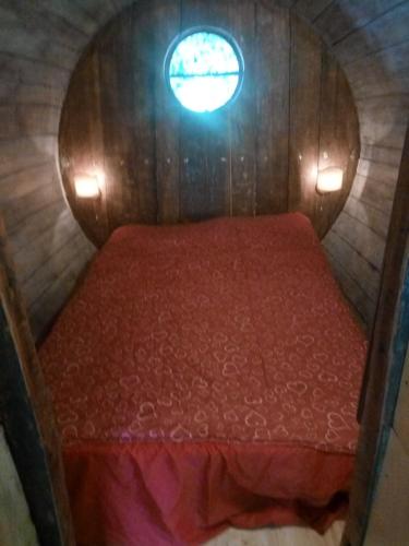 a bed in a small room with a window at terrebio bungalow in Visnadello