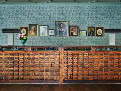 a large wooden cabinet with pictures on a wall at Graduate by Hilton Charlottesville in Charlottesville