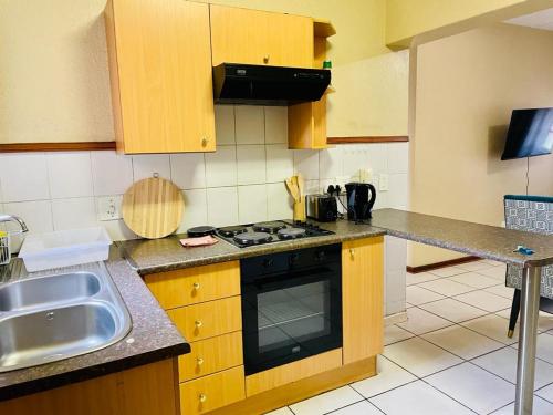 a kitchen with a sink and a stove top oven at Tafre Hospitality @ Stratford, Menlyn in Pretoria