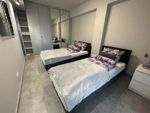 2 aparte bedden in een kamer met spiegels bij Wenecjanska Comfort Apartment, free parking, self check-in 24h in Poznań