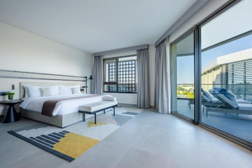 - une chambre avec un lit et une grande fenêtre dans l'établissement Fraser Suites Al Liwan, à Manama