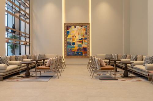 a waiting room with chairs and a painting on the wall at Fraser Suites Al Liwan in Manama