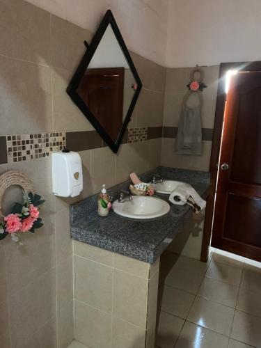 een badkamer met een wastafel en een spiegel bij Chimborazo Rey lodge hotel in Guaranda