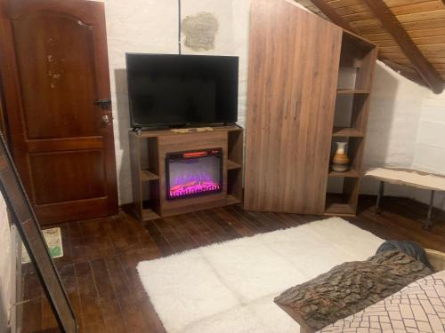 een woonkamer met een tv en een open haard bij Chimborazo Rey lodge hotel in Guaranda