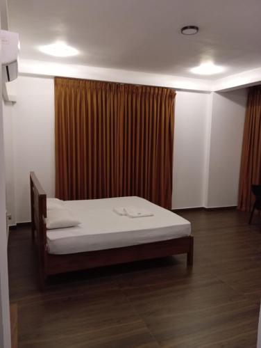 - une chambre avec un lit et un rideau dans l'établissement ROCK VIEW inn, à Padukka