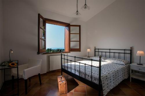 a bedroom with a bed and a window at Poggio di mare in Castelluzzo