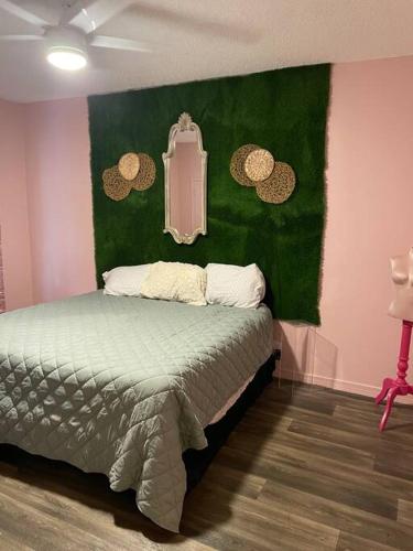 - une chambre dotée d'un lit avec un mur vert dans l'établissement 5- Bed Pink house ( Close to Sports Center ), à West Monroe