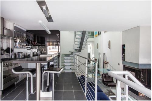 une cuisine avec un escalier, une table et des chaises dans l'établissement maison d'architecte de 6 niveaux à Paris, à Paris