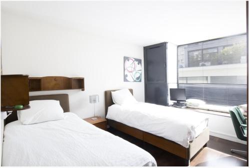 Cette chambre dispose de deux lits et d'une fenêtre. dans l'établissement maison d'architecte de 6 niveaux à Paris, à Paris