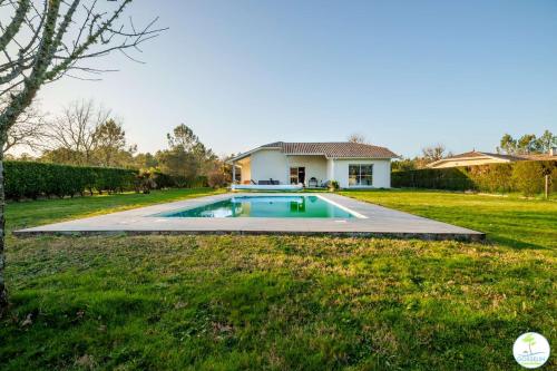 une maison avec une piscine dans une cour dans l'établissement Magnifique Villa pour 10 personnes à Parentis en Born, à Parentis-en-Born
