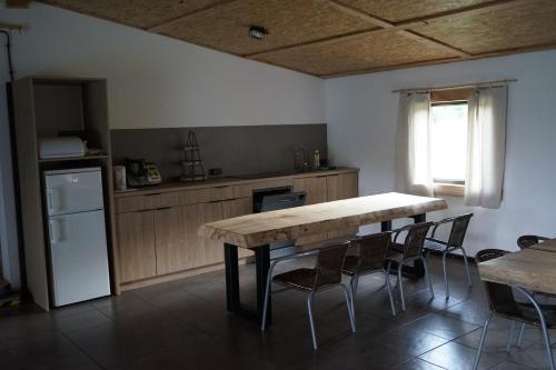 a kitchen with a table and chairs and a refrigerator at Siedlisko na łące in Dąbrówno