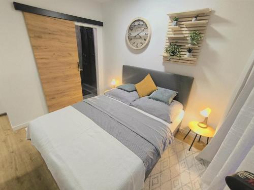 a bedroom with a bed and a clock on the wall at Park Bôrik 4YOU & Free Parking in Žilina