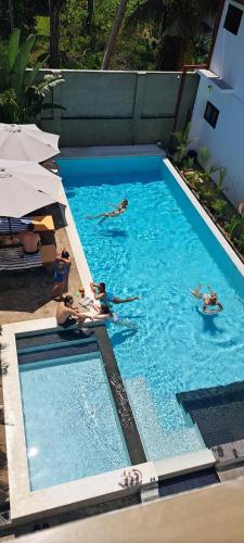 un grupo de personas nadando en una piscina en קקטוס אתגרים, en Ahangama