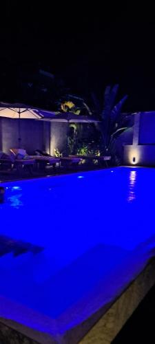 a blue swimming pool in a house at night at קקטוס אתגרים in Ahangama