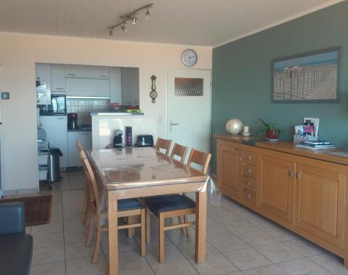 eine Küche mit einem Holztisch und Stühlen im Zimmer in der Unterkunft Zon, zee en ontspanning in Middelkerke