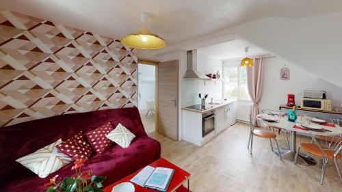 un salon avec un canapé rouge et une cuisine dans l'établissement Maison TYMAO de 14 personnes en bord de Mer, à Étables