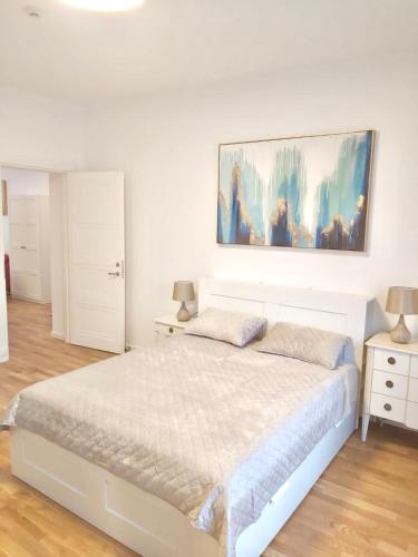a bedroom with a bed and a painting on the wall at Luxury Central Apartment Easy Kaunas in Kaunas