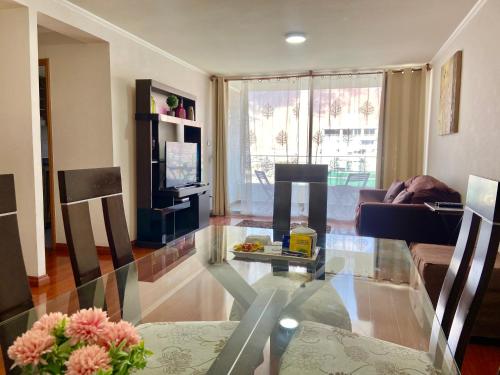 a living room with a glass table and a couch at Apartamento Alma Capital in Iquique