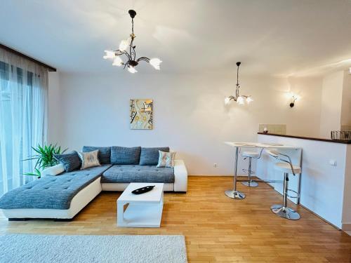 ein Wohnzimmer mit einem Sofa und einem Tisch in der Unterkunft BP Kazinczy Centrum Prime Suites in Budapest