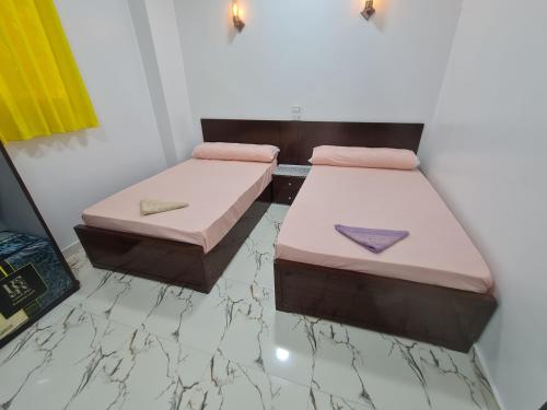 two beds in a room with a marble floor at Esmerada in Aswan