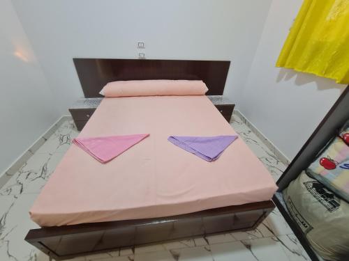 a bed in a room with pink and purple sheets at Esmerada in Aswan