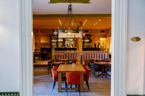 a dining room with tables and chairs and a chandelier at Hotel Schimmelpenninck Huys in Groningen
