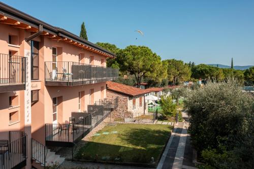 an apartment building with balconies and a yard at Regina del Garda Suite in Toscolano Maderno