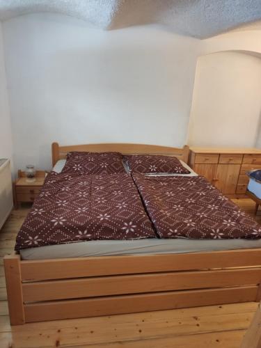 a bed in a room with a wooden bed frame at Alfapartmány in Krásná Lípa