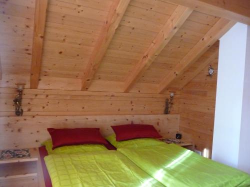 Cama en habitación con techo de madera en Haus Andreas - Chalet 306, en Turracher Höhe