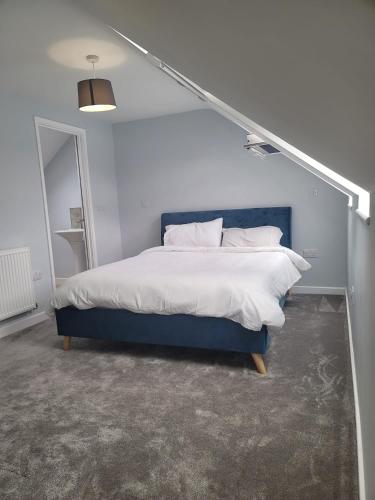 a bed with a blue headboard in a room at Eye Haven in Peterborough