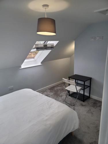 a bedroom with a bed and a table and a window at Eye Haven in Peterborough