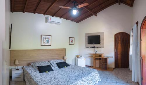 a bedroom with a bed and a flat screen tv at HOTEL POUSADA PARAÍSO in Itapevy