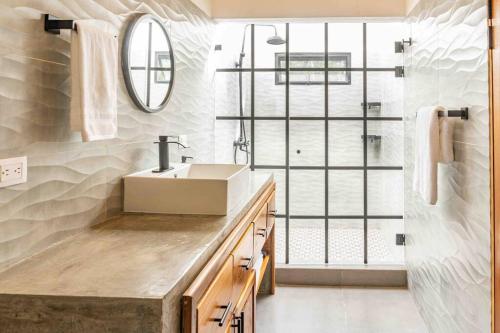 W łazience znajduje się umywalka i lustro. w obiekcie Casa Tranquila BRAND NEW Villa with Pool w mieście Sámara