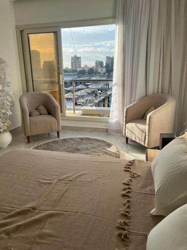a bedroom with a bed and a view of a harbor at 127-3 النيل in Cairo