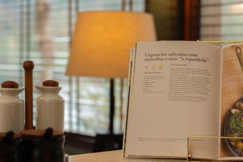a book sitting on top of a table with a lamp at Quinta da Azenha in Amarante