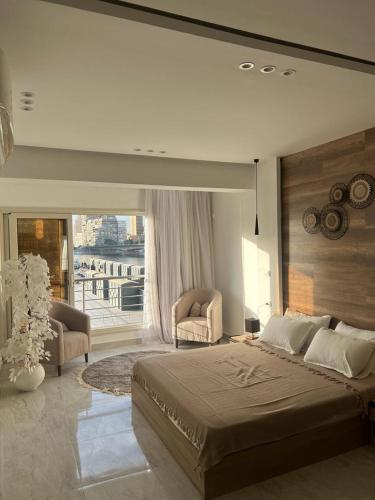 a bedroom with a large bed and a large window at 127-3 النيل in Cairo