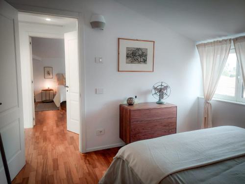 a bedroom with a bed and a dresser and a window at Villa Ines in Riva del Garda
