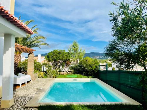 a swimming pool in the backyard of a house at Aldeia de Juzo Cascais Villa in Aldeia de Juso