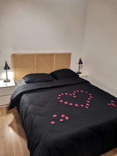 a bed with a black comforter with hearts on it at *Appartement Moderne/2 minutes du métro* in Saint-Ouen