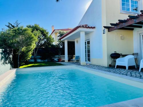 a swimming pool in front of a house at Aldeia de Juzo Cascais Villa in Aldeia de Juso